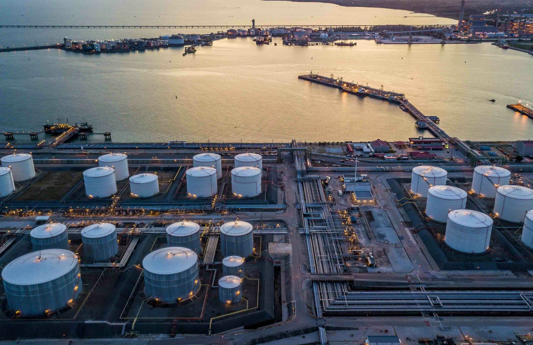 Aerial view storage tank farm at night, Tank farm storage chemical petroleum petrochemical refinery product at oil terminal, Business commercial trade fuel and energy transport by tanker vessel.